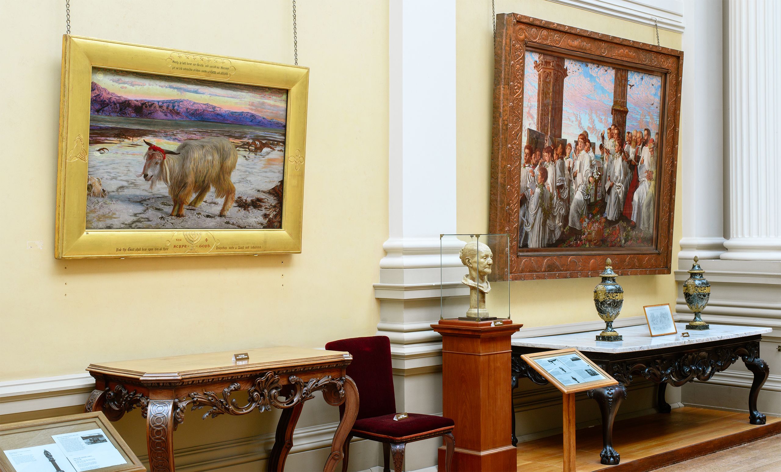 Framed painting of a white goat in a barren landscape hanging on the gallery wall